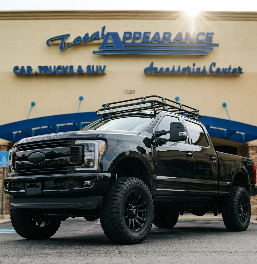 Black Ford truck with roof rack in front of Total Appearance store