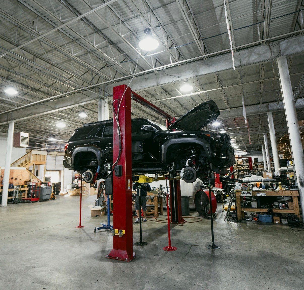 Car on a lift in a large warehouse or garage setting